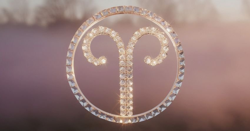 Aries zodiac symbol golden ram sign on purple background