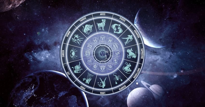 Silver zodiac wheel surrounded by glowing blue and purple cosmic energy against a dark celestial background