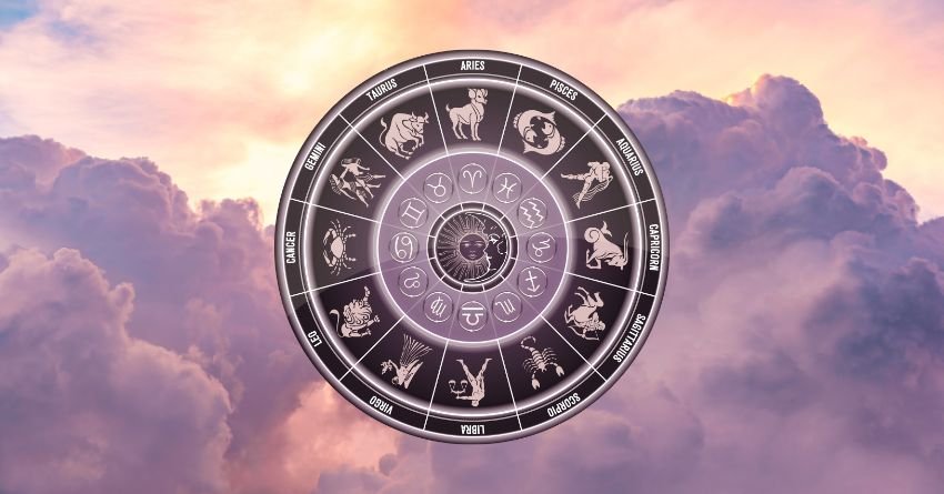 Silver zodiac wheel floating above soft pink and purple clouds in a dreamy sky