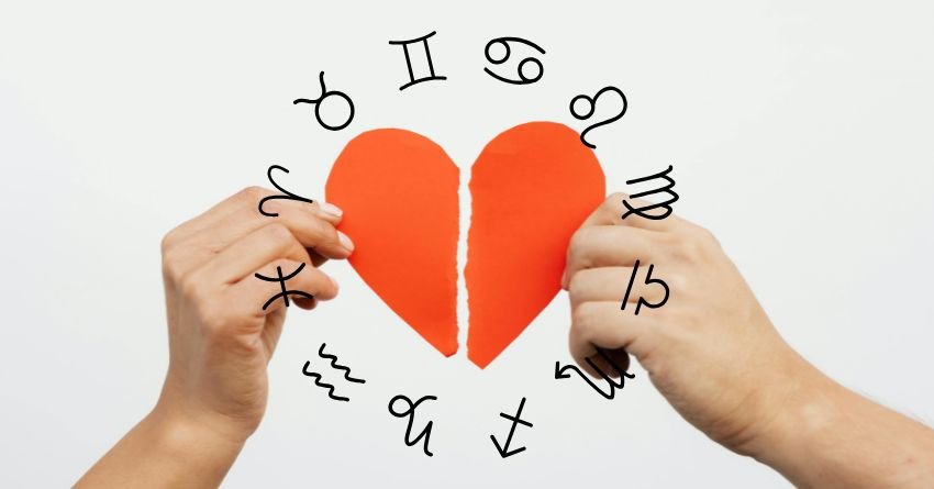 Hands holding a broken red heart surrounded by zodiac symbols on a light background