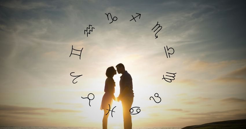 Two silhouetted figures standing beneath floating zodiac symbols against a warm glowing sky