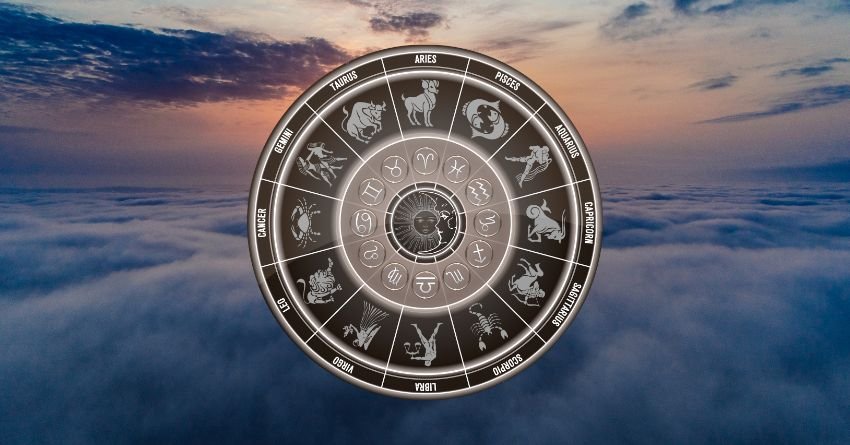Golden zodiac wheel above a dramatic sunset sky with glowing clouds