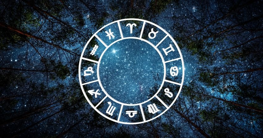 Glowing blue zodiac wheel on a dark dramatic background with streaks of cosmic light