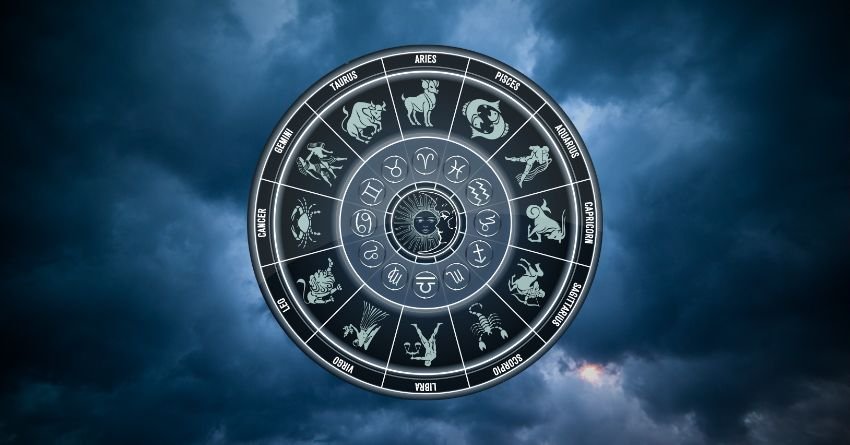 Glowing silver zodiac wheel surrounded by deep blue cosmic clouds and mysterious celestial light