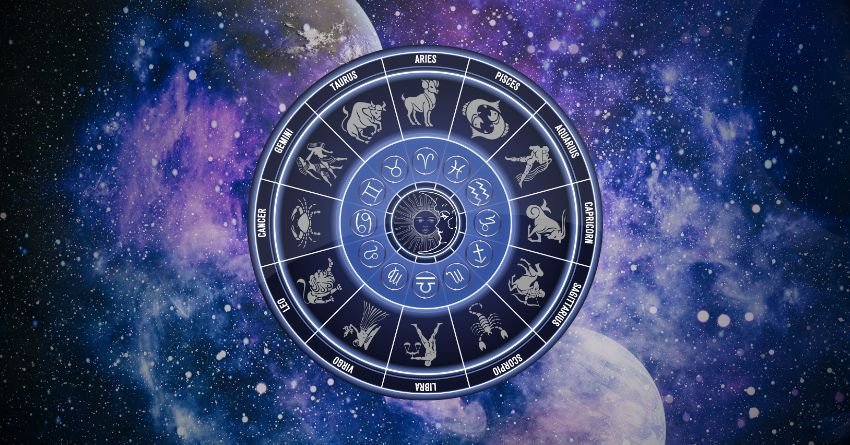 Glowing silver zodiac wheel surrounded by deep blue and purple cosmic clouds with mysterious celestial light