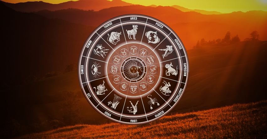 Glowing golden zodiac wheel against a dramatic orange sunset sky with dark cosmic clouds